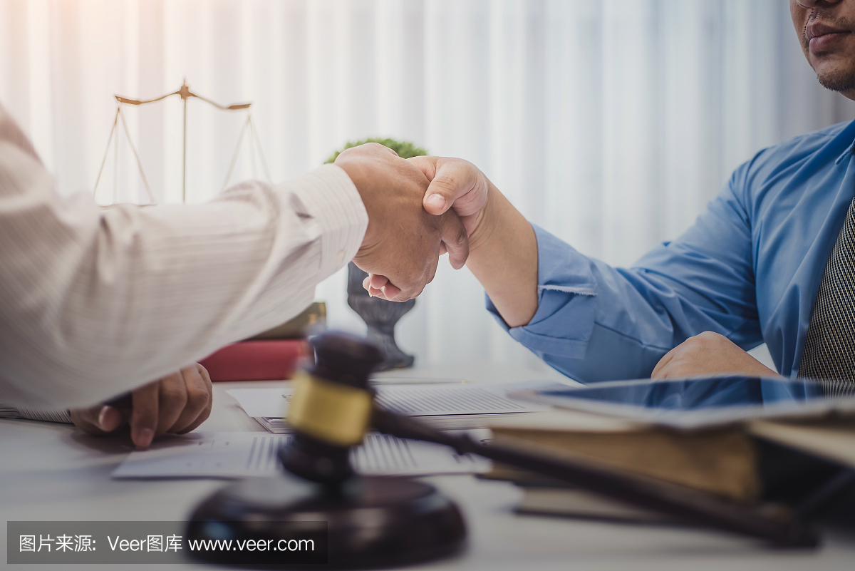 商人与律师在办公室讨论合同协议后握手。正义与法律,律师,法官,概念。