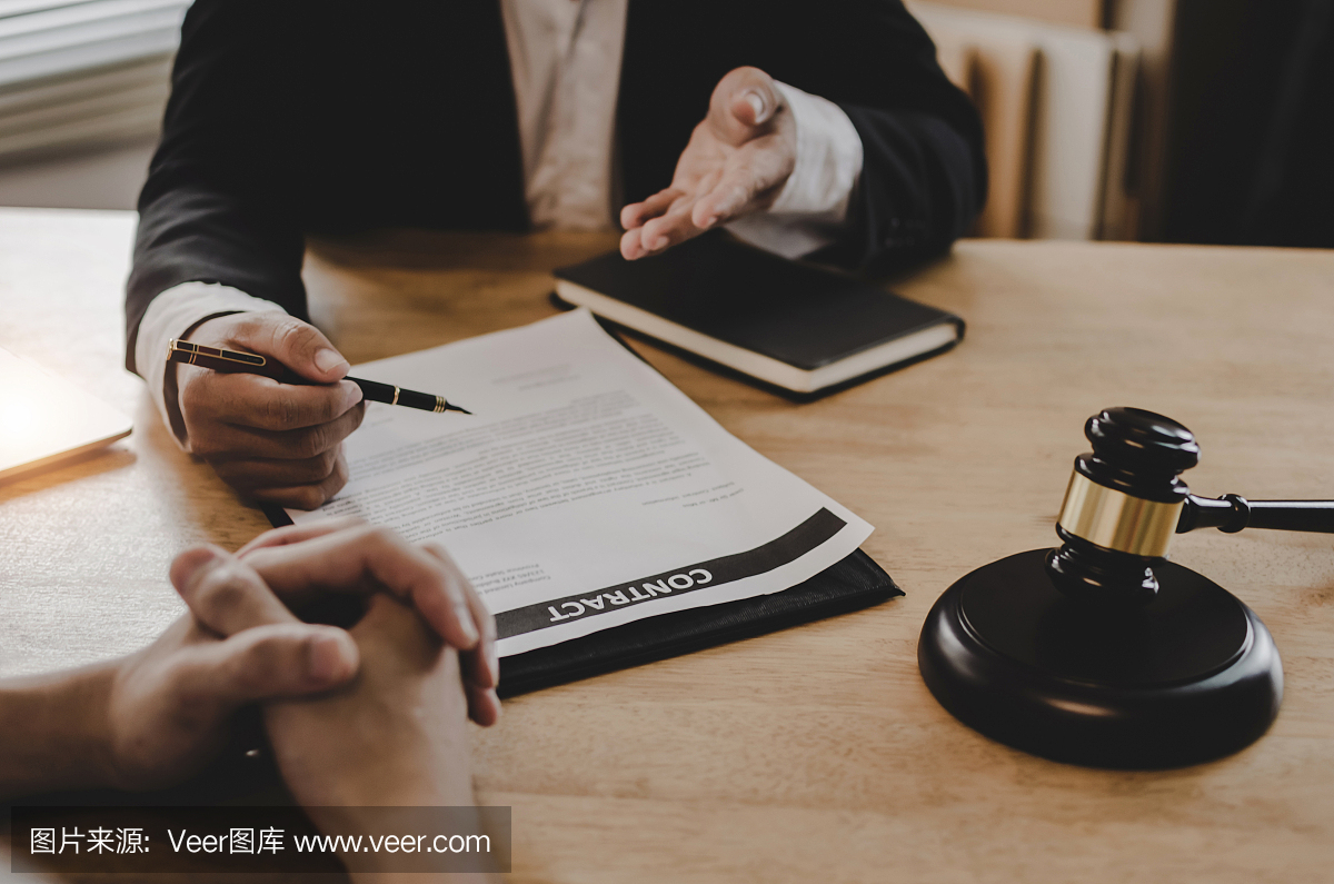法律顾问,公证人或司法律师与客户讨论合同文件和木制法官槌在法庭办公室的桌子上,商业,司法法律,保险和法律服务理念